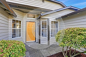 Entrance porch with yellow front door and large windows