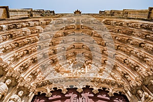 Perspective of archivolts and tympanum with derocative religious figures from the entrance portal of the Monastery of Santa Maria photo
