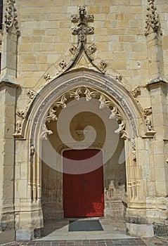 Entrance with red door at gothic style catholic church