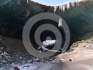 Entrance of the Sapphire Ice Cave in BreiÃ°amerkurjÃ¶kull glacier, VatnajÃ¶kull national park, south Iceland with standing people.