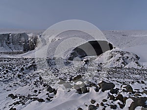 Entrance of the Sapphire Ice Cave, located in BreiÃ°amerkurjÃ¶kull glacier, VatnajÃ¶kull, south Iceland, with rough landscape.