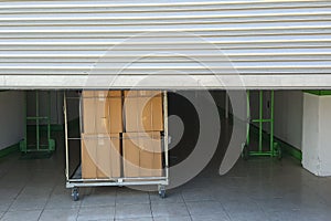 Entrance into self storage units, big cart with boxes in front, metal gate