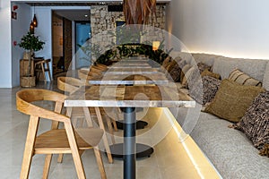 Entrance of a small luxury hotel with empty wooden tables out of season. Vacation concept