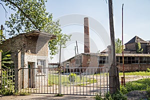 Entrance to an Abandoned factory and warehouse with its distinctive brick chimnet in Eastern Europe, in Pancevo, Serbia