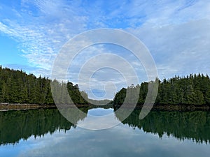 Entrance to a bay between two small island with blue skies and streaky clouds along the Central Coast of British photo