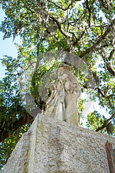 A somber Stature guards the Entrance to the Bonaventure Cemetery in Savannah Georgia photo