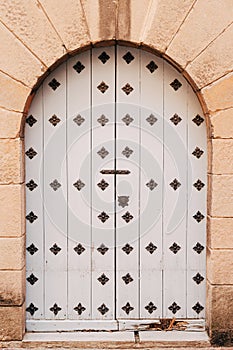 The entrance to the building is made of white double-barrelled doors with a metal forging in the arch.