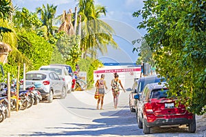 Entrance to caribbean coast beach with parked cars Tulum Mexico