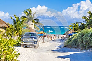 Entrance to caribbean coast beach with parked cars Tulum Mexico