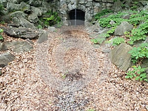 Entrance to coal mine with metal door and leaves