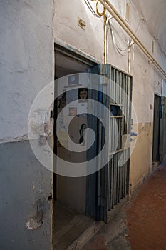 Entrance to a Dark Room of a Prison Cell with Hanging Newspaper Clippings on the Wall
