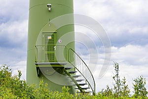 Entrance to a green wind power plant, windmill, windfarm in the forest with cloudy sky. Green energy