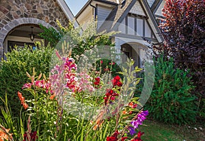 Entrance to a home through a beautiful garden with colorful flowers. Plants and flowers in in a garden