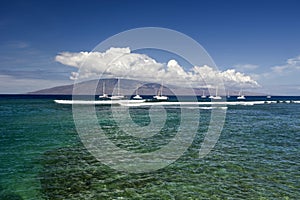 Entrance to Lahaina Harbor with boats and the island of Lanai, Maui, Hawaii