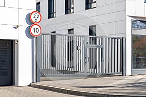 Entrance to the modern residential complex. Lattice gates with a wicket and an gate to the underground parking