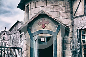 Entrance to the old Church with a red cross over the door