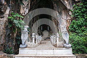 Entrance to Am Phu Cave with bridge and statues