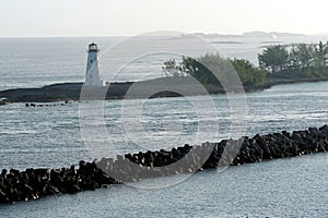 Entrance to the port of Nassau in the Bahamas with old white lighthouse on a breakwater.