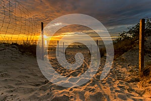 Entrance to a sandy beach during a beautiful sunset