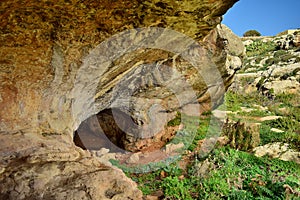 Entrance to a small cave formed in a valley, in Maltese limestone, Ghar il-Buz, Malta
