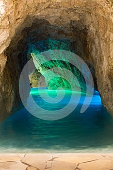 Entrance to stone cave with blue water. Beautiful spa resort. Rocky sea cave.