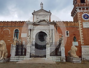 The entrance to the Venice arsenal with a forged door and two statues of lions