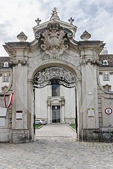 entrance to the white baroque and neoclassic palace with beautiful carved decorative elements. Black gates with wrought iron