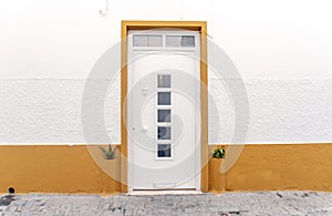 Entrance to whitewashed house with yellow decoration in Olhao, Portugal