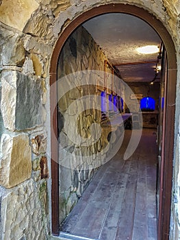 Entrance to the wine cellar through an open door with a round arch, stone walls