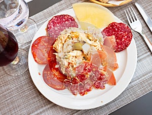 Entremeses of cold cuts served with Russian salad