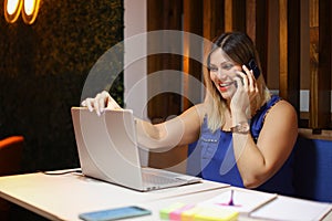 Entrepeneur woman talking on phone so happy closing a laptop
