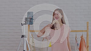 Entrepreneur of Asian young woman live streaming video online for selling her dress and clothes to customer in platform or