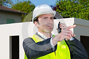 entrepreneur on building site using walkie talkie