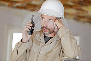 entrepreneur on building site using walkie talkie