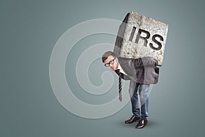 Entrepreneur carrying a large stone with engraved IRS letters