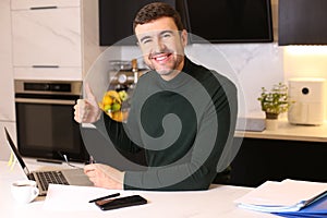 Entrepreneur giving a thumbs up from home office