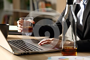 Entrepreneur hands drinking alcohol working on laptop at homeoffice