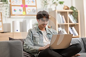 Entrepreneur handsome business asian man wear shirt sitting on couch working online with computer laptop smile happiness and relax