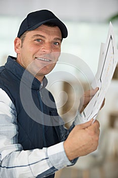 entrepreneur in house under construction checking plan