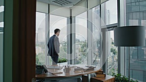 Entrepreneur looking office window. Smart businessman thinking business ideas.