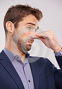 Entrepreneur, man and studio with smell or hand gesture on white background for stinky place and corporate. Closeup