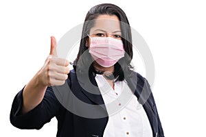 Entrepreneur woman wearing surgical mask making thumb up gesture