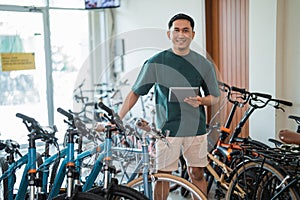 entrepreneurial man stands smiling at the camera holding a digital tablet