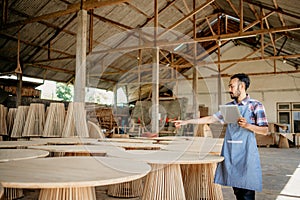 entrepreneurial man works in a woodcraft shop using a tablet