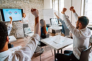 Entrepreneurs and business people achieving goals, celebrating on team building meeting in office.