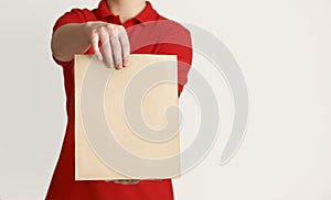 Entrust fragile items to courier. Courier holds out paper bag to client photo