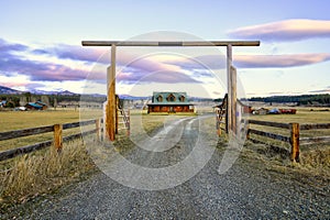 Entry gate to a nice wooden ranch home with beautiful landscape.