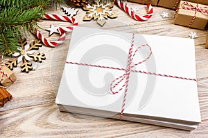 Envelope with blank sheet of paper on Christmas background - fir branch, pine cones, red ribbon, star and heart of