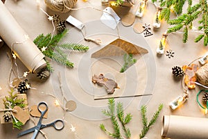 Envelope with congratulations for Christmas and new year in eco-friendly materials: kraft paper, live fir branches, cones, twine.