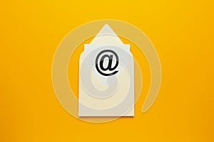 Envelope with e-mail symbol on yellow background, concept of corporate communication and marketing mailings photo